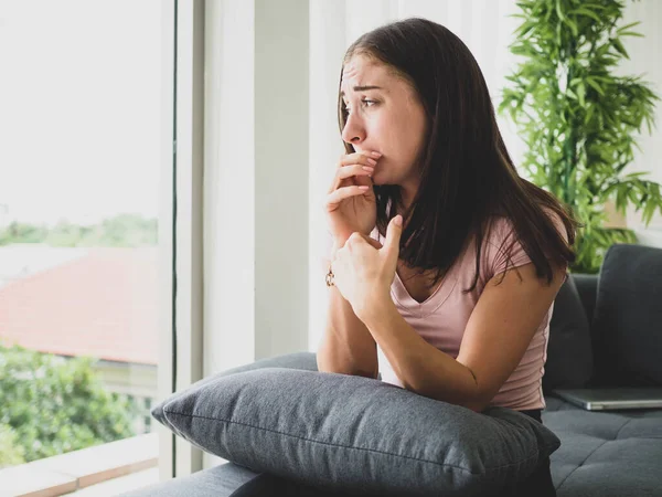 Genç, çekici ve üzgün bir kadın depresif bir şekilde evinde oturuyor endişeli ve hayal kırıklığına uğramış depresyon sorunu yaşıyor yalnız üzgün bir kadın ve odasında ağlıyor..