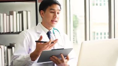 Teletıp konsepti - Doktor internetten hastanın konuşmasını dinliyor ve klinikte bir tartışma yapıyor. Hastane ofisinde hasta sağlığı verileriyle çalışan bir doktor..