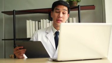 Teletıp konsepti - Doktor internetten hastanın konuşmasını dinliyor ve klinikte bir tartışma yapıyor. Hastane ofisinde hasta sağlığı verileriyle çalışan bir doktor..
