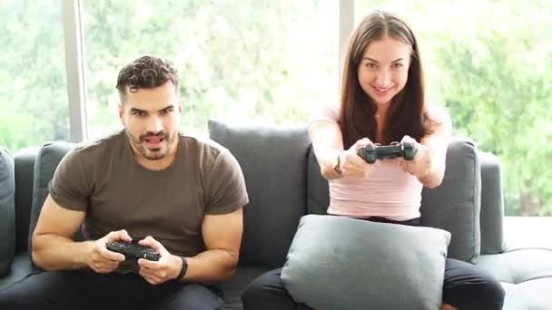 Covid 19の状況で自宅でビデオゲームをプレイしている幸せな若者 ベストホームコンセプトを維持します 面白い若いカップル勝利ビデオゲーム 楽しみを持っています — ストック動画
