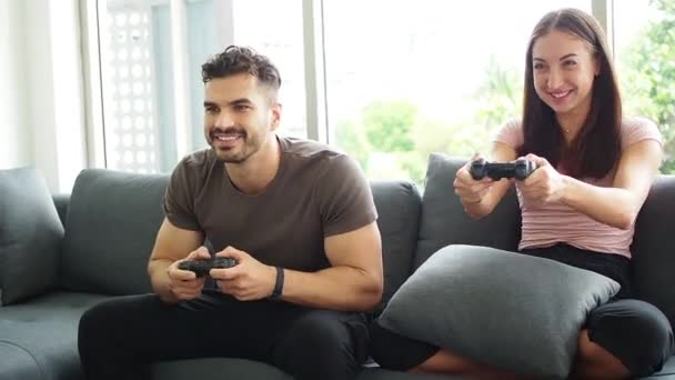 Covid 19の状況で自宅でビデオゲームをプレイしている幸せな若者 ベストホームコンセプトを維持します 面白い若いカップル勝利ビデオゲーム 楽しみを持っています — ストック動画