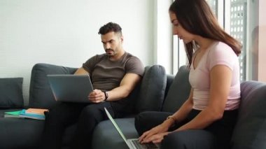 Evde çalışan çift, evden çalışmak için bilgisayar kullanırken sosyal mesafeler. Aile ilişkisi ve çift kavramı. Çift aşıklar evde kalır ve yeni normallerle sosyal mesafeyi korurlar..