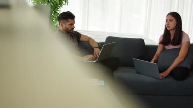 Evde çalışan çift, evden çalışmak için bilgisayar kullanırken sosyal mesafeler. Aile ilişkisi ve çift kavramı. Çift aşıklar evde kalır ve yeni normallerle sosyal mesafeyi korurlar..