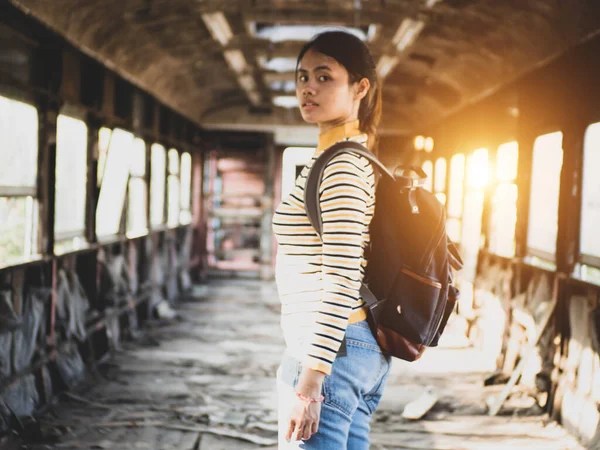 Woman traveler with the train for traveling. Young hipster woman traveling at train station.