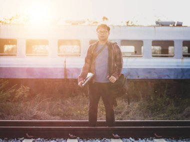 Tren istasyonundaki hippi turist Asyalı gezgin portresi. Seyahat konsepti. Seyahat ederken rahatla. Tren yolu, hippi treni yolcu seyahat süresi dolmak üzere. Tren yolu üzerinde duran adam..