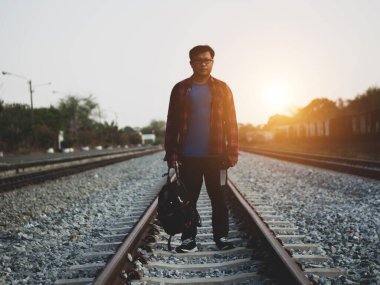 Tren istasyonundaki hippi turist Asyalı gezgin portresi. Seyahat konsepti. Seyahat ederken rahatla. Tren yolu, hippi treni yolcu seyahat süresi dolmak üzere. Tren yolu üzerinde duran adam..
