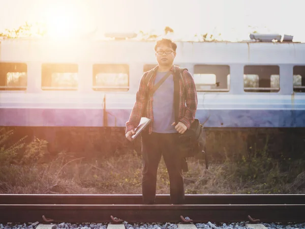 Tren istasyonundaki hippi turist Asyalı gezgin portresi. Seyahat konsepti. Seyahat ederken rahatla. Tren yolu, hippi treni yolcu seyahat süresi dolmak üzere. Tren yolu üzerinde duran adam..