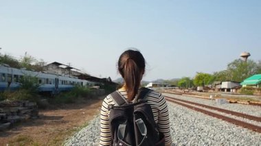 Kadın gezgin gezgin tren yolunda tek başına yürüyor..