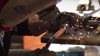 Kesici dairesel metal kullanan işçiler, ışık saçan kıvılcımlara sahipler, çok çalışan ve çeliği kesen insanlar, atölyedeki kıvılcımlarla bir çeliği kesiyorlar.