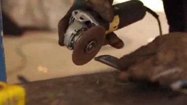 Kesici dairesel metal kullanan işçiler, ışık saçan kıvılcımlara sahipler, çok çalışan ve çeliği kesen insanlar, atölyedeki kıvılcımlarla bir çeliği kesiyorlar.