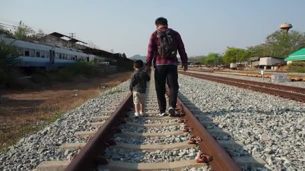 男と彼の息子の旅行者バックパッカーは鉄道を歩く — ストック動画