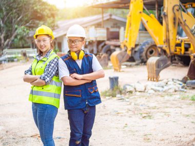 İnşaat alanında çalışan mühendisler. Kadın ve erkek açık bir kuyuda çalışıyor. İnşaat mühendisleri şantiyede birlikte çalışıyorlar..