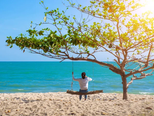 Plajda salıncak çalan kız. Uzun bir hafta sonu ve tatil tatilleri kumsalda yavaş bir hayat sürdü..