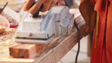 Bir marangoz elektrikli bir planör kullanıyor.