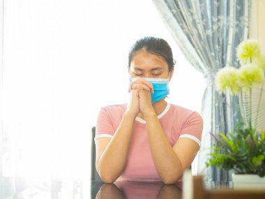 Dua eden kız Tanrı 'ya tapıyor ve Coronavirus krizleri için evden dua ediyor. Dua et evde, internette, dua eden ellerde, evde ibadet et, Covid-19' un yakında iyileşmesi için..