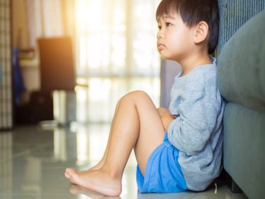 Çocuklar modern evin içinde yerde, sevimli küçük bir çocuk yerde oturuyor..