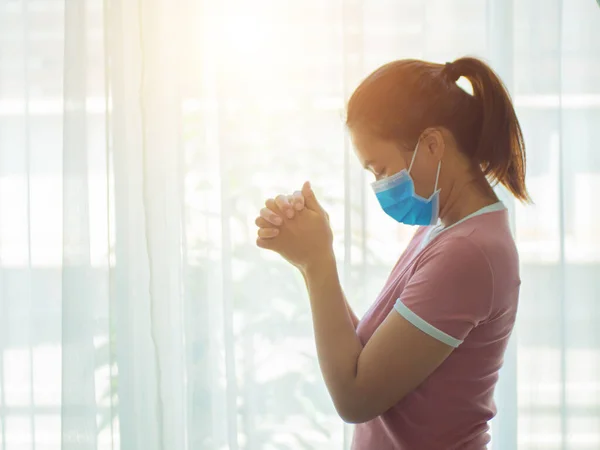 Dua eden kız Tanrı 'ya tapıyor ve Coronavirus krizleri için evden dua ediyor. Dua et evde, internette, dua eden ellerde, evde ibadet et, Covid-19' un yakında iyileşmesi için..