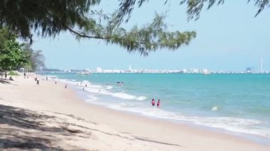 Tayland, Rayong 'da tropik bir sahil. İnsanlar plajda rahatlayıp oyun oynuyorlar..