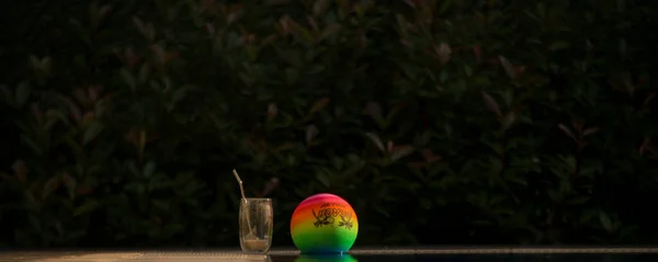 Havuz kenarında renkli top ve kahve kupası.