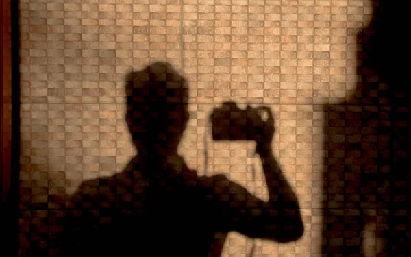 Duvara yansıyan fotoğrafçının gölgesi