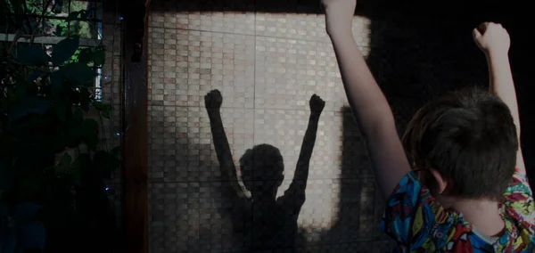 Küçük çocuğun zafer sevinci duvara yansıdı.