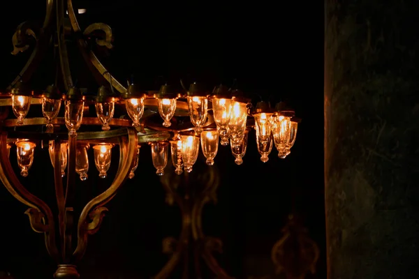 Siyah arkaplanda bir sürü ampul olan avize