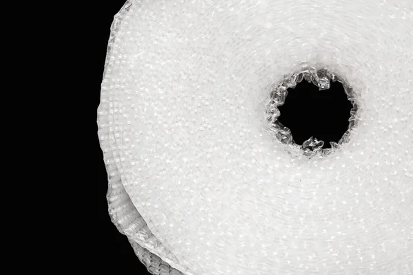 Roll of white bubble cellophane film, packaging with air bubbles close-up isolated on a black background