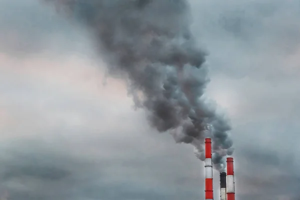 Environmental pollution, environmental problem, smoke from the chimney of an industrial plant or thermal power plant on a background of grey sky