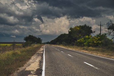Uzun ve ıssız bir yol ve yaklaşan fırtınanın manzarası