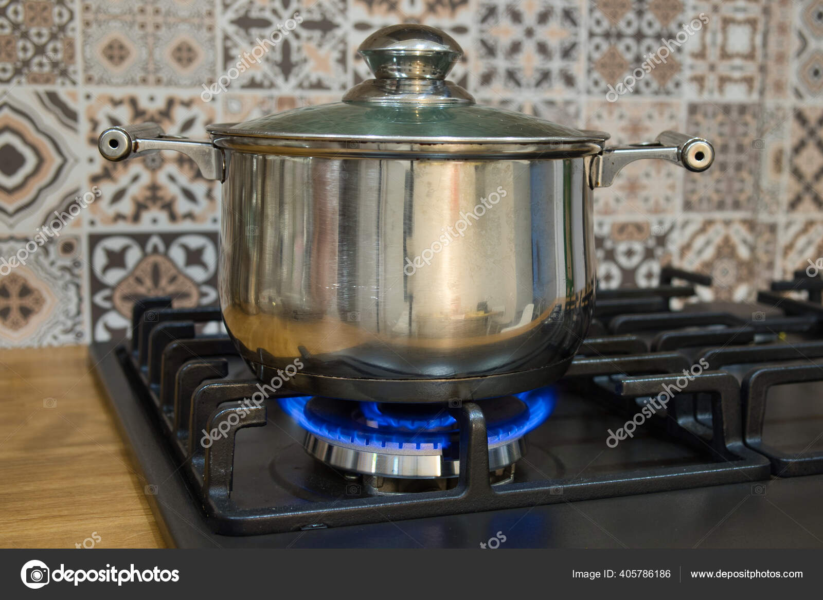 Cooking on a gas stove. The pot on gas burner. Stock Photo by ©aryutkin  405786186