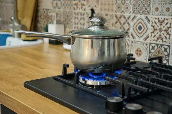 Cocinar en una estufa de gas. La olla en el quemador de gas. — Foto de Stock