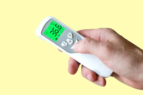 Hand Holding Contactless Thermometer Showing Temperature Degrees Celsius Yellow Background — Stock Photo, Image