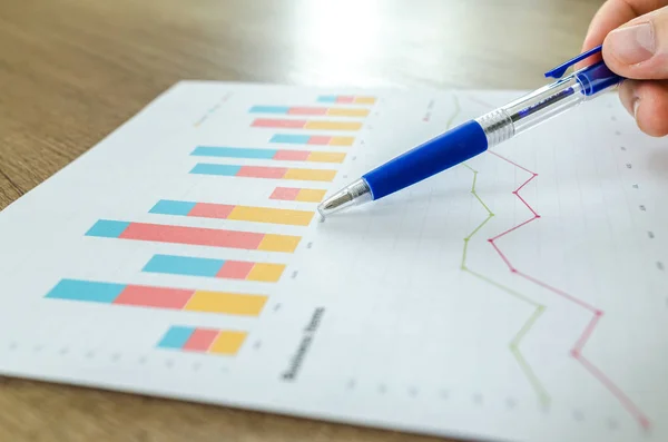 Mann Zeigt Geschäftsdiagramm Auf Holztisch — Stockfoto