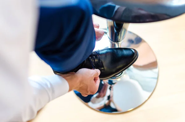 Business man is putting on elegant shoes