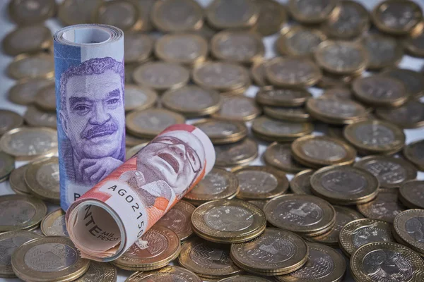 roll of Colombian pesos banknotes on a coin background