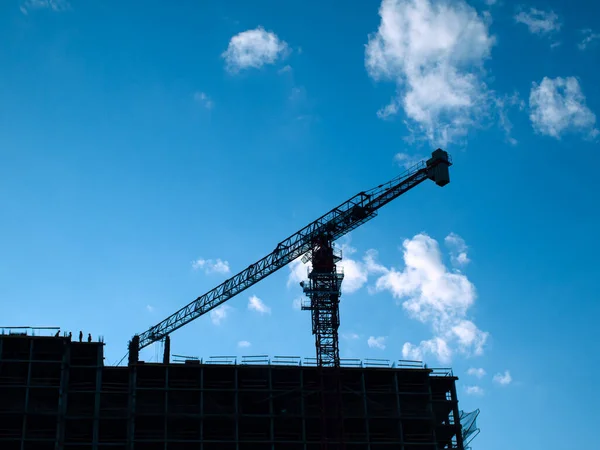 Construction site silhouette with crane on the sky background