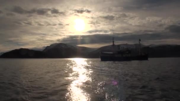 Iate de navio de expedição no fundo do pôr-do-sol no céu cinza e nuvens do Ártico . — Vídeo de Stock