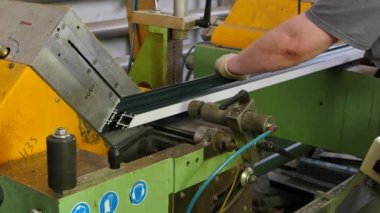 Çalışan eller fabrikasında makine alüminyum profil daire testere ile kesme.