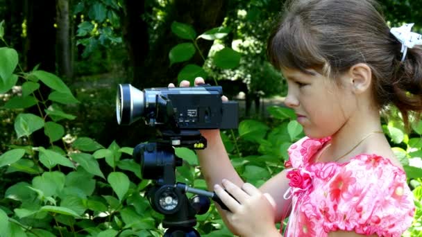 Junges Mädchen blickt in Videokamera auf dem Hintergrund des grünen Parks. — Stockvideo