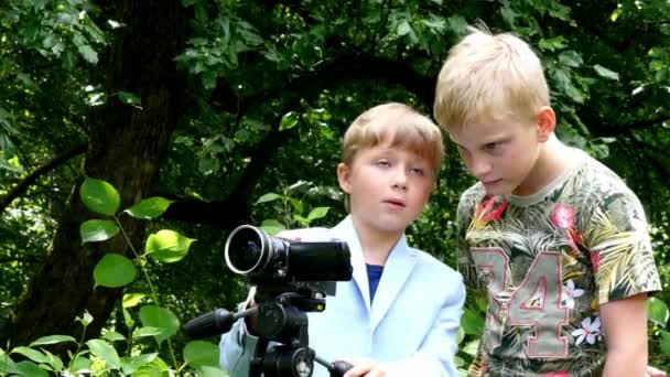 Fiatal fiúk kamerával lő film zöld háttér jellege. — Stock videók