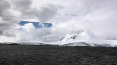 Dalgalar ve bulutlar kar rock Okyanusu Antarktika arka plan üzerinde.