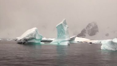 Buzdağı ve Antarktika'nın okyanusta yüzen buz kütlesi buz.