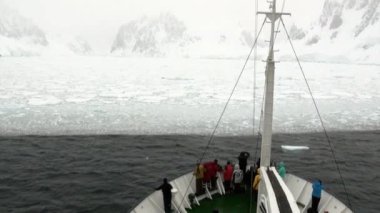 Antarktika okyanusunda gemideki insanlar.