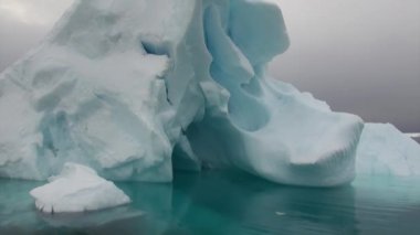 Buzdağı ve Antarktika'nın okyanusta yüzen buz kütlesi buz.