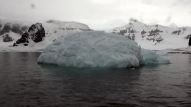 Buzdağı ve Antarktika'nın okyanusta yüzen buz kütlesi buz.