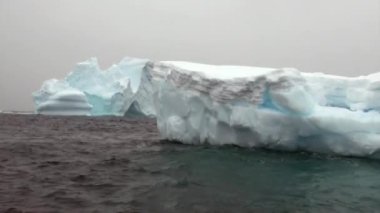 Buzdağı ve Antarktika'nın okyanusta yüzen buz kütlesi buz.