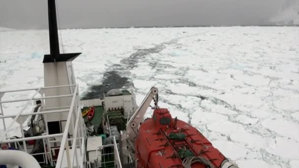 Pessoas no navio em segundo plano de gelo no oceano da Antártida . — Vídeo de Stock