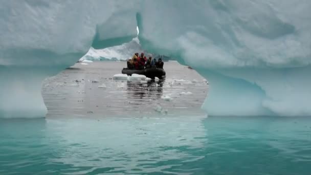 Menschen in Schlauchboot nahe Eisscholle und Eisberg des antarktischen Ozeans. — Stockvideo