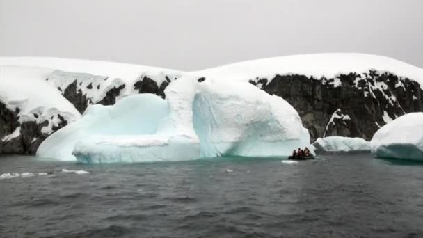 Pessoas em barco de borracha perto de Ice floe e iceberg do oceano Antártica. — Vídeo de Stock