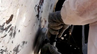 İşçiler tersanede tamirat sürecinde metali boyayla parçalıyorlar..